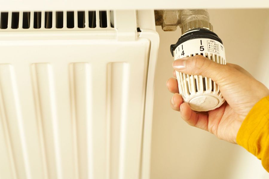 Hand stelt een radiatorthermostaat bij
